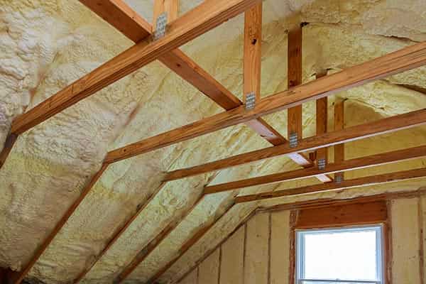 Spray foam insulation applied to ceiling, exposed beams.